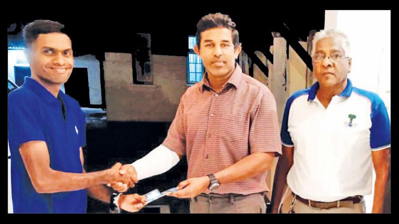 Bandara Wekadapola the London Society of Rugby Football Union (LSRFUR) presents the whistle to up-and-coming referee Udara Lakshan (left) who is the son of veteran rugby referee D. Nimal in the presence of WPRRS president Wimal Senanayake
