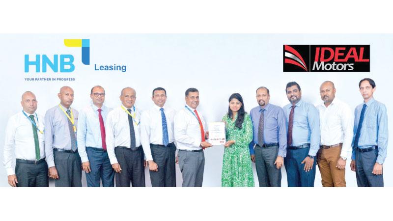 HNB Deputy General Manager, Retail & SME Banking, Sanjay Wijemanne exchanges the MoU with Ideal Motors Director, Legal and Marketing, Nimisha Welgama. Looking on are (from left): HNB Asst. Manager, Business Development, Leasing, Mahesh Rathnayake, HNB Asst. Manager, Leasing, Roshan De Silva, HNB Head of Leasing, Susith Perera, HNB Head of Micro Finance, Vinodh Fernando; HNB AGM, PFS, Kanchana Karunagama; Ideal Motors DGM, Corporate Sales, Malaka Vehalla, Ideal Motors Head of Sales, Kasun Fernando, Mahindra 