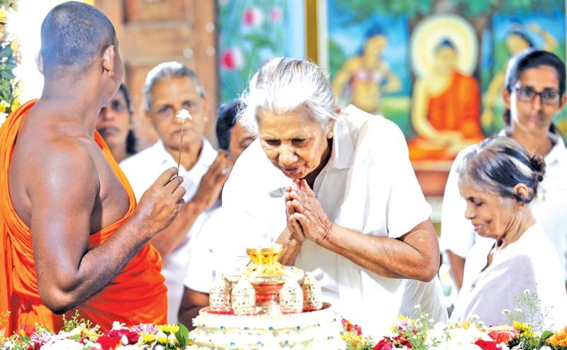 An Upasika (a Buddshist  laywoman) pays homage to  Archaeology Department-protected  Sacred Neelagiri relics at Dharma Rashmi Poson Zone.