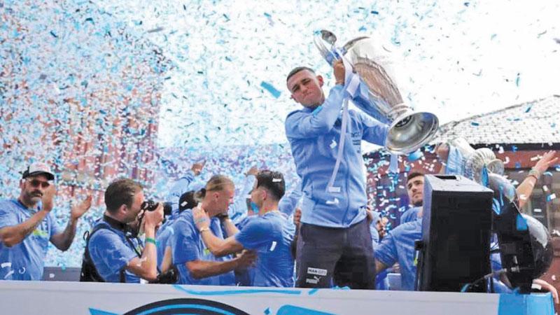 Phil Foden shows off the Champions League trophy