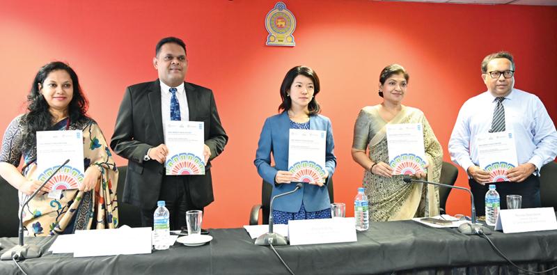 State Minister of Finance, Shehan Semasinghe receives the report from officials at the launch