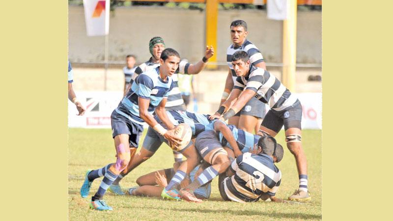 Wesley College fly-half Darrian de Zilva attempts to sling out a pass against St. Joseph’s College in their match at the Royal Complex ground yesterday (Pic Thilak Perera)