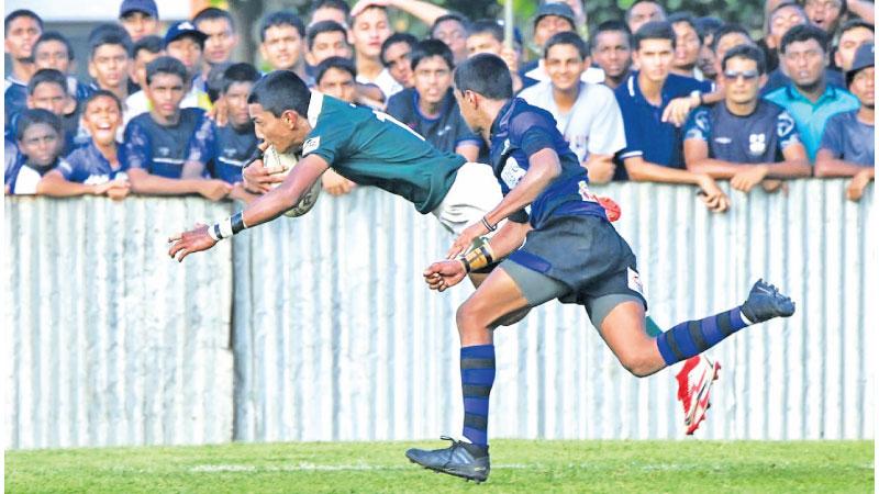 Isipathana College winger Rinesh Silva goes over for a try in their match against S. Thomas’ College at Mount Lavinia yesterday