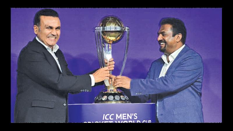 Retired greats Virendra Sehwag (left) and Muttiah Muralidaran hold on to the World Cup at an ICC launch