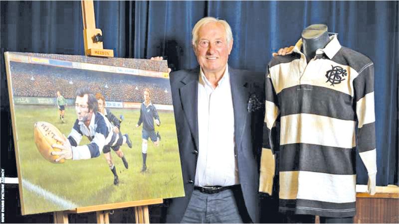 Sir Gareth Edwards alongside a painting of his famous match
