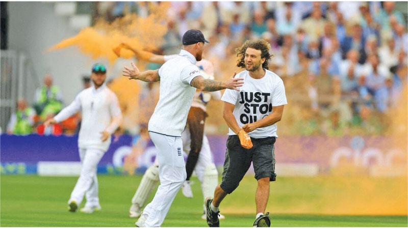 Ben Stokes attempts to stop a protester
