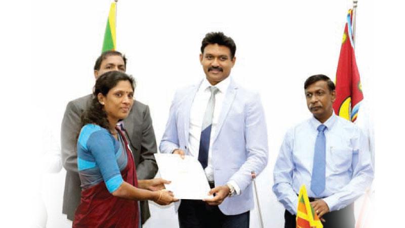 Governor of the Eastern Province Senthil Thondaman presents an appointment letter to a teacher