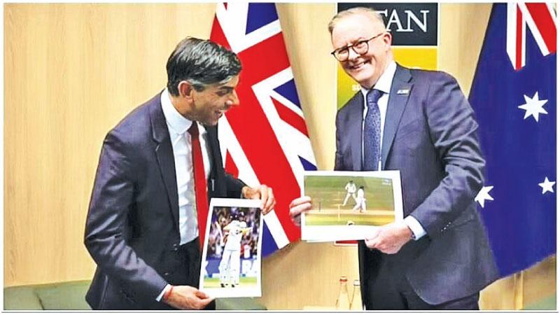 UK Prime Minister Rishi Sunak (left) and Australia Prime Minister Anthony Albanese exchange Ashes cricket memorabilia on the sidelines of the Nato summit in Lithuania