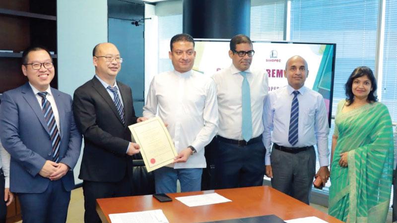 From left: Sinopec Energy Lanka Deputy General Manager Arthur Cheng Anxiang , CEO Yu Yuhaa, State Minister Dilum Amunugama, BOI Chairman Dinesh Weerakkody and BOI officials after signing the agreement. 