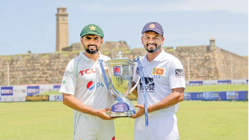 Captains Babar Azam (Pakistan,at left) and Dimuth Karunaratne (Sri Lanka) hold the trophy they will play  for in the two Test cricket series starting today in Galle 
