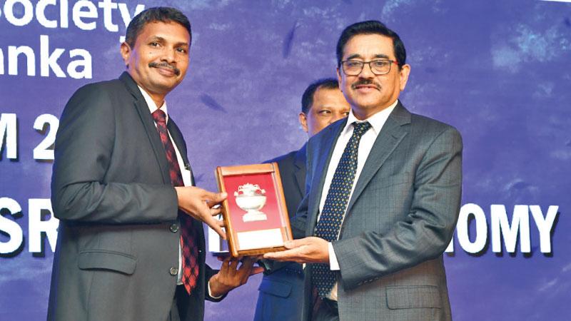 CFA President Aruna Perera presents a token of appreciation to Dr. Nandalal Weerasinghe