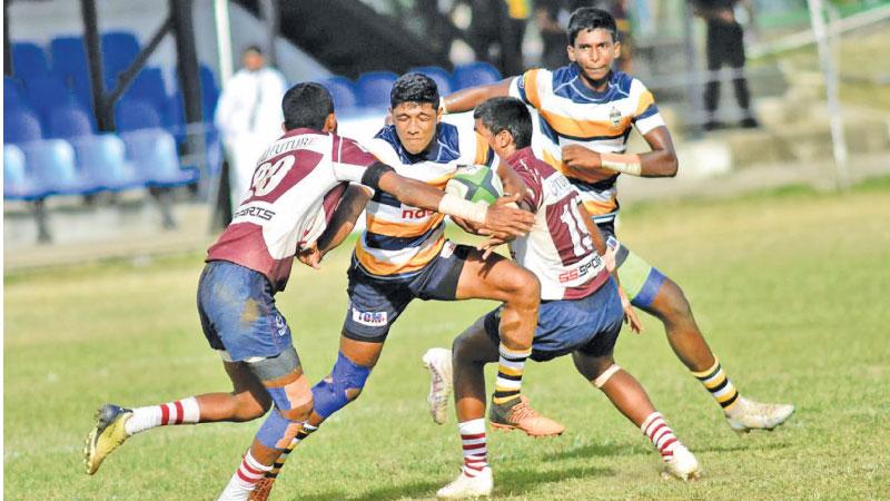 St. Peter’s College player Januka Ranasinghe attempts to shove out Science College defenders Shankeer Thuwan and Sasitha Kaluarachchi in their inter school leag rugby match at Bambalapitiya yesterday. The Peterites won 29-0 posting their fifth win in a row