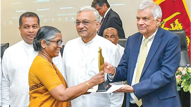 President Ranil Wickremesinghe presents an award to an official of a public sector institution at a ceremony organised by the Public Accounts Committee.  Pic: Courtesy PMD
