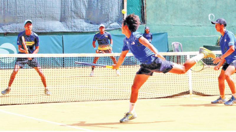 Sri Lanka’s doubles pair of Thehan Wijemanne (left) and Dhilvan Herath anticipate the return by the Malaysian pair (Pic by Nissanka Wijeratne)