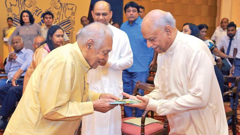Dr. Leel Gunasekara presenting the first copy of his book The Petition to Prime Minister Dinesh Gunawardena. Yadamini Gunawardena MP is also in the picture.