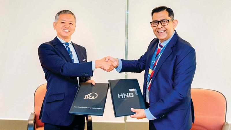 JICA Chief Representative, Yamada Tetsuya (left), and HNB, DGM, Wholesale Banking Group, Damith Pallewatte exchange the agreement.