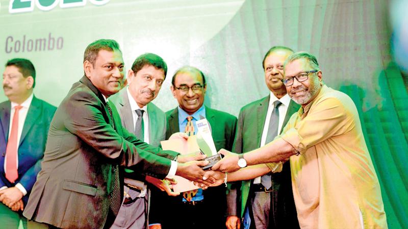 State Minister Suren Raghavan presents the Platinum award to Tokyo Cement Group officials. Minister Susil Premajayantha looks on.