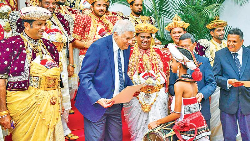 President Wickremesinghe presents an award to a young artiste at  the ceremony to award prizes to the artistes  who excelled in the Kandy Esala Perahera. Pic: Courtesy PMD