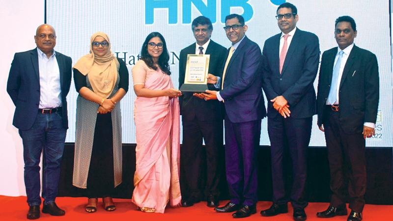 HNB Deputy General Manager, Wholesale Banking Group, Damith Pallewatte (third from right) and HNB Assistant General Manager,  Strategy, Priyanka Wijeratne (third from left) receive the award from the Secretary to the President, Saman Ekanayake (centre).